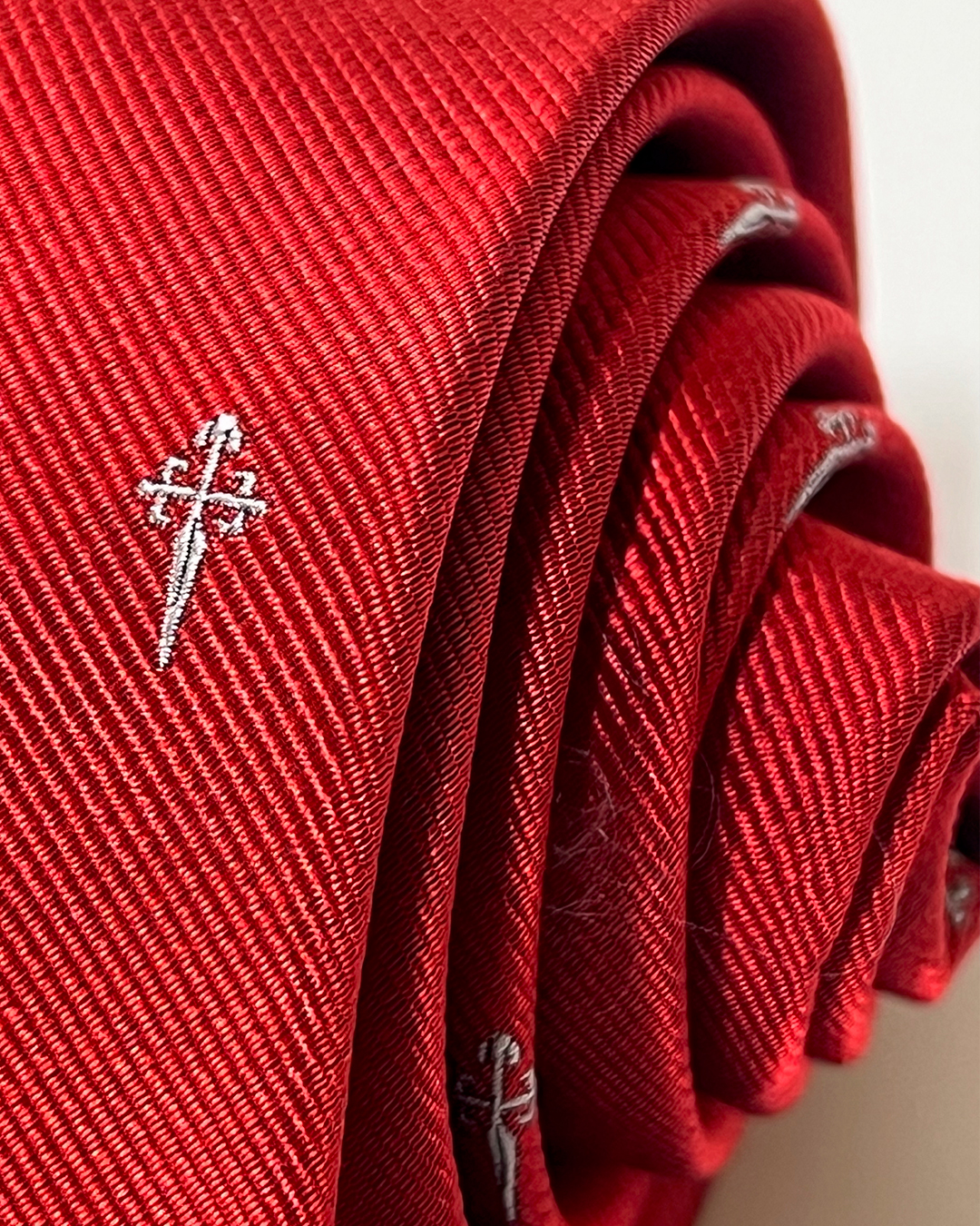 Corbata roja 100% seda natura de JACOBSLAND, con cruces grises inspiradas en el Camino de Santiago.